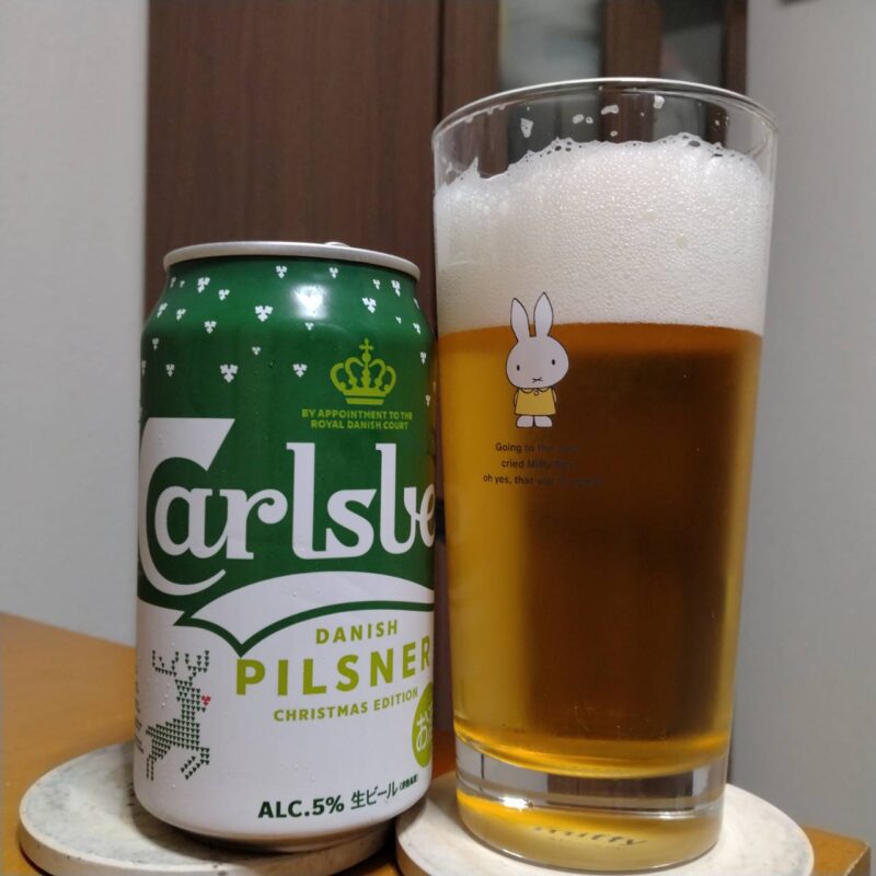 サントリーカールスバーグ〈北欧からの贈りもの〉とグラスに注いだサントリーカールスバーグ〈北欧からの贈りもの〉